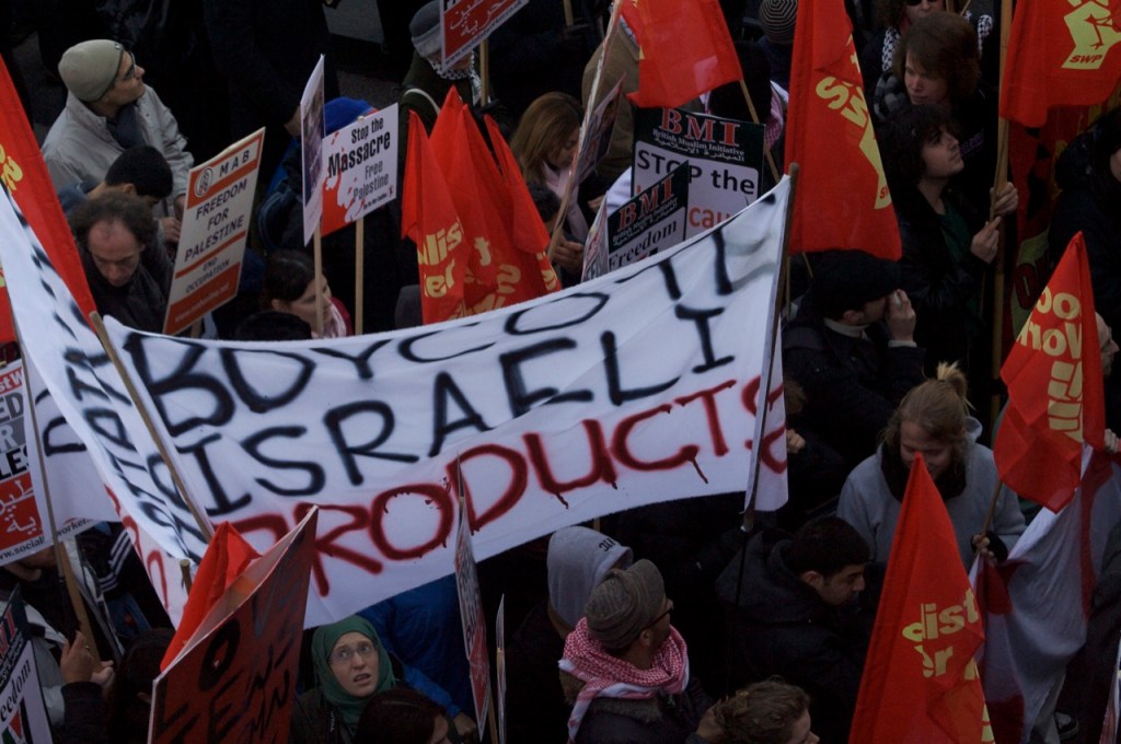 BDS supporters protesting in London. The poster reads, "Boycott Israeli Products" souce Wikipedia
